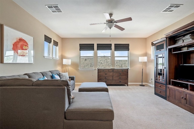 living room featuring light carpet, baseboards, and a ceiling fan