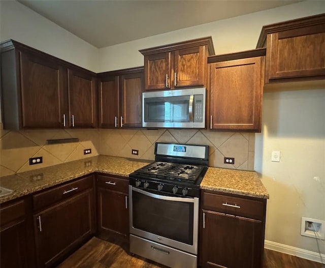 253 Eagle Brook Ln, Buda, TX 78610 - kitchen featuring appliances with stainless steel finishes, light stone countertops, dark wood-style floors, backsplash, and dark brown cabinetry