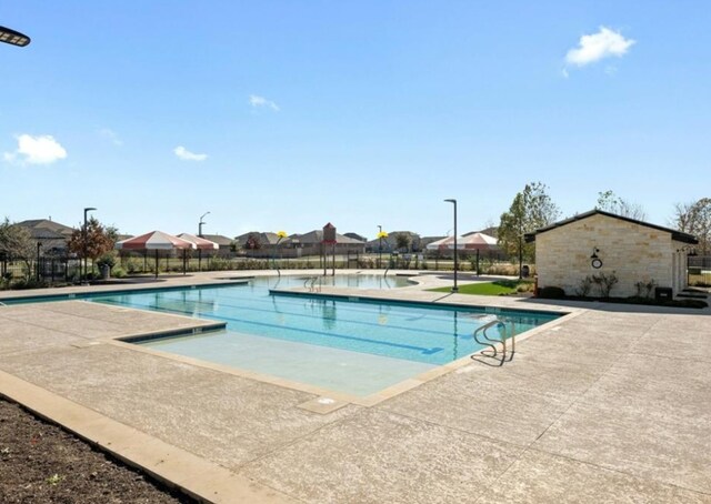 community pool featuring a patio and fence