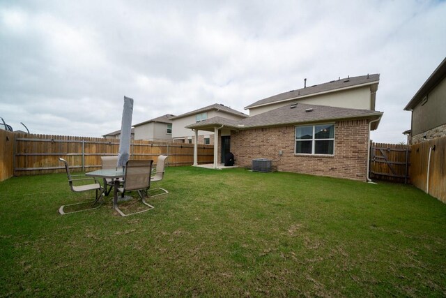back of house featuring brick siding and central AC unit