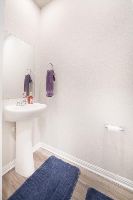 bathroom with baseboards and wood finished floors