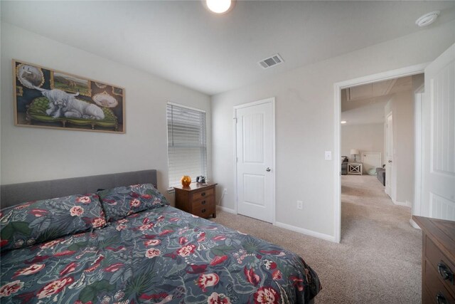 carpeted bedroom with attic access and baseboards