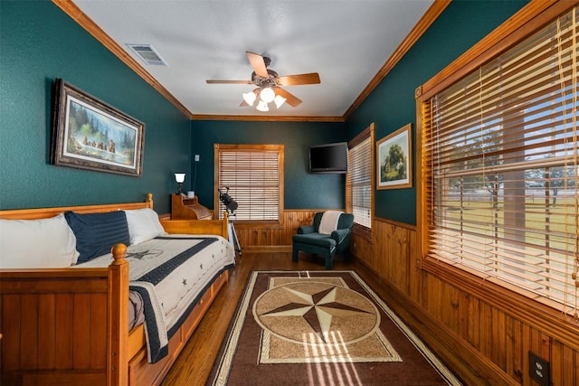 155 Gabriel Farms Dr, Hutto, TX 78634 - bedroom with multiple windows, wood finished floors, a wainscoted wall, ornamental molding, and wood walls