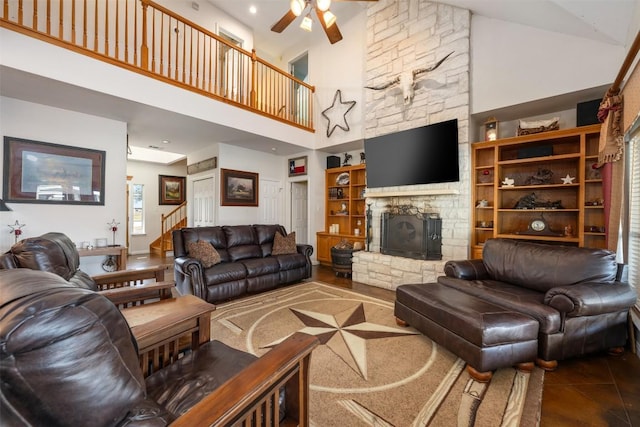 155 Gabriel Farms Dr, Hutto, TX 78634 - tiled living area featuring high vaulted ceiling, a ceiling fan, a stone fireplace, stairway, and built in features