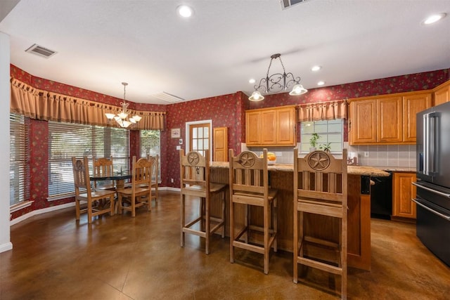 155 Gabriel Farms Dr, Hutto, TX 78634 - kitchen featuring a chandelier, black appliances, wallpapered walls, baseboards, and a center island