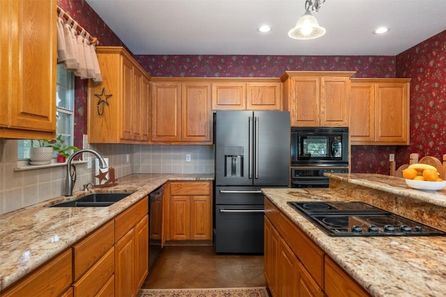 155 Gabriel Farms Dr, Hutto, TX 78634 - kitchen featuring black appliances, wallpapered walls, a sink, tasteful backsplash, and brown cabinets