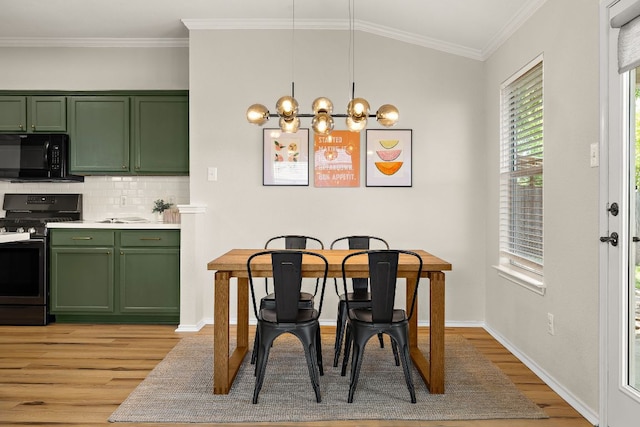 dining room with light wood-type flooring, a chandelier, crown molding, and baseboards