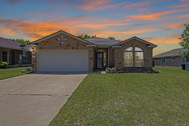ranch-style home featuring stone siding, a garage, driveway, and a yard