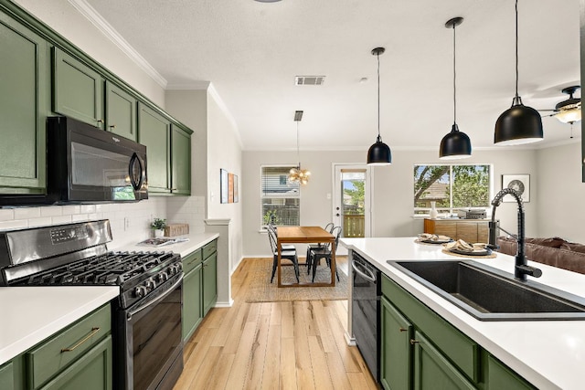 kitchen featuring green cabinetry, gas range oven, black microwave, a sink, and dishwashing machine