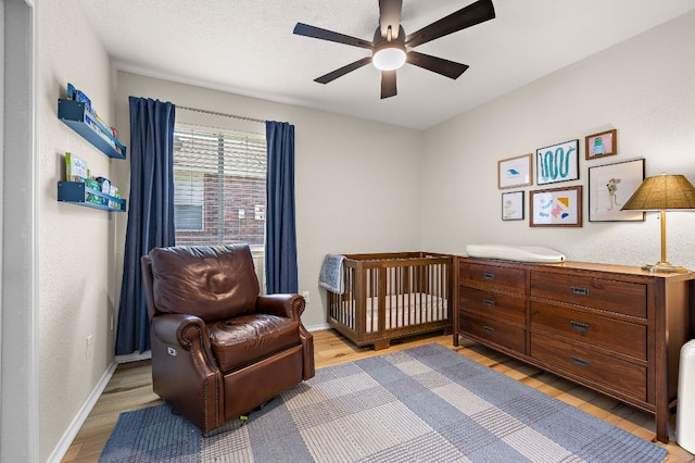 1107 Remington Dr, Leander, TX 78641 - bedroom with light wood-type flooring, a ceiling fan, and a nursery area