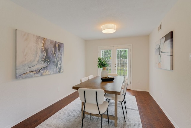 dining space with dark wood-style flooring, baseboards, and french doors