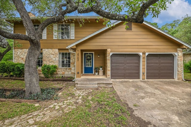 view of front of property with stone siding, concrete driveway, and a garage