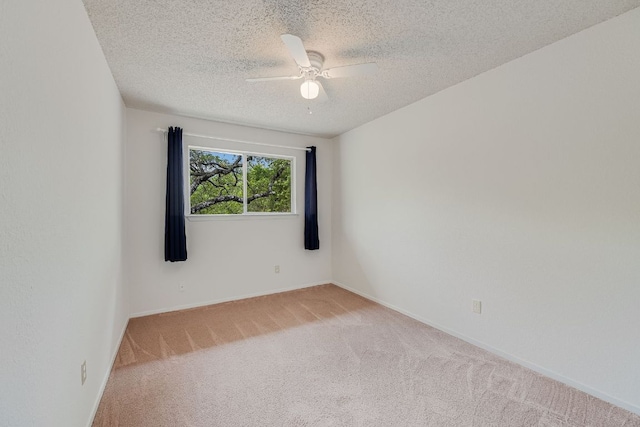 unfurnished room with carpet floors, ceiling fan, a textured ceiling, and baseboards