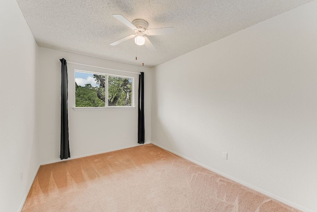 empty room with light carpet, a textured ceiling, and a ceiling fan
