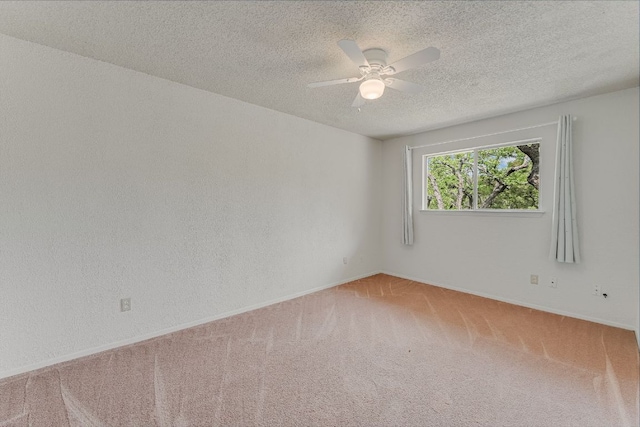 unfurnished room with carpet floors, a textured ceiling, baseboards, and a ceiling fan