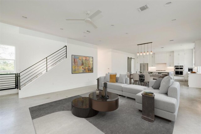 1305 Village W Dr, Austin, TX 78733 - living room with stairway, a ceiling fan, and finished concrete floors