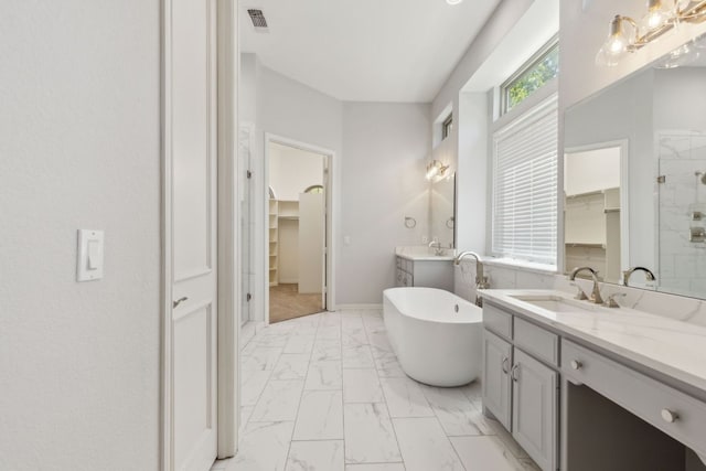 805 Parkwood Ct, Mckinney, TX 75072 - full bathroom with marble look tile flooring, two vanities, a walk in closet, a stall shower, and a freestanding bath