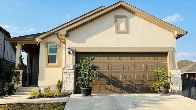 view of front of property featuring stucco siding, driveway, and a garage