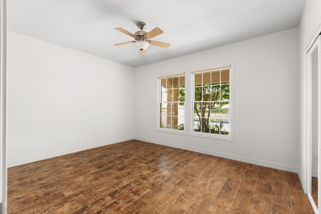 unfurnished room with wood finished floors, ceiling fan, and baseboards