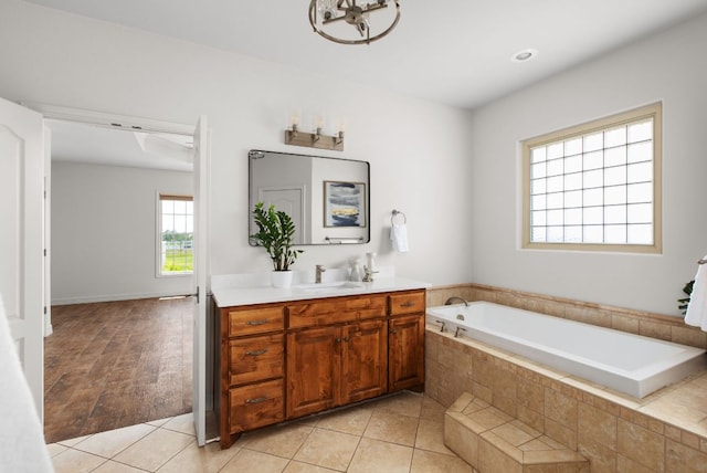 full bath featuring a bath, vanity, and tile patterned floors
