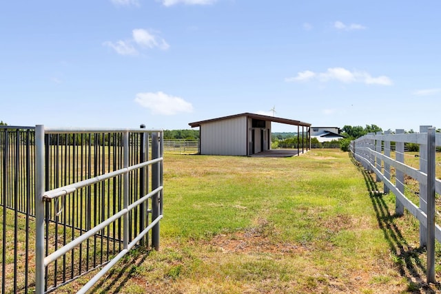 view of yard with an outdoor structure, an exterior structure, fence, and a carport