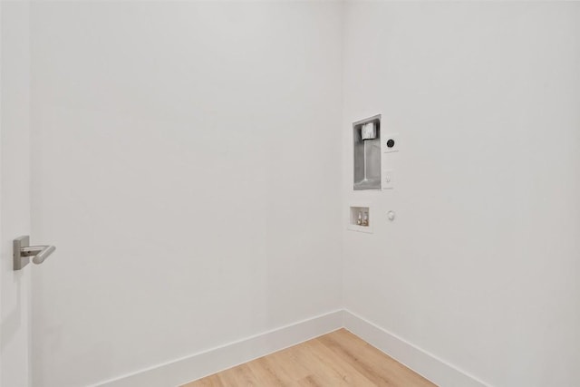 washroom with electric dryer hookup, hookup for a washing machine, baseboards, and light wood-style floors