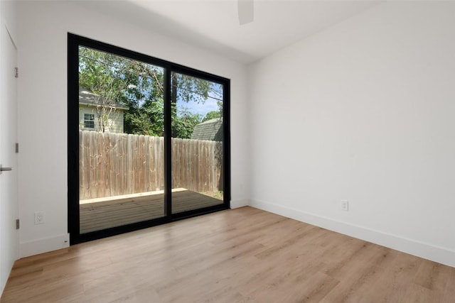 unfurnished room featuring wood finished floors, baseboards, and a ceiling fan