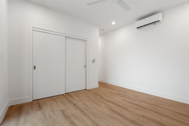 2107 Maple Ave Unit B, Austin, TX 78722 - unfurnished bedroom with an AC wall unit, light wood-type flooring, a closet, baseboards, and recessed lighting
