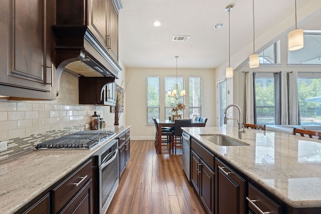 kitchen featuring a sink, appliances with stainless steel finishes, plenty of natural light, wood finished floors, and recessed lighting