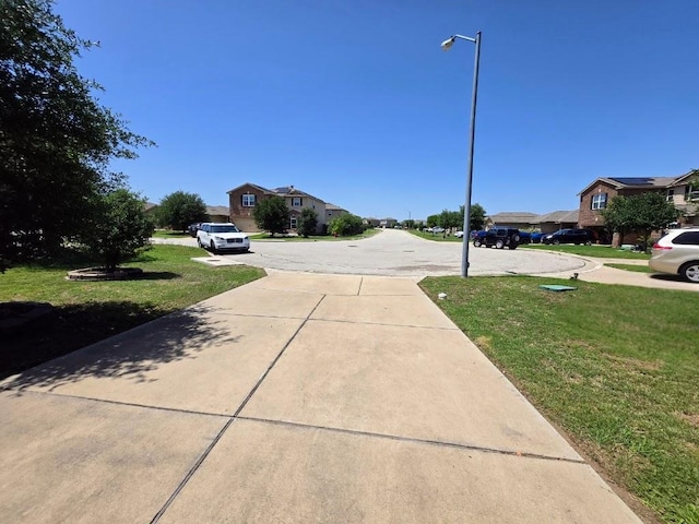 336 Farmer Ln, Jarrell, TX 76537 - view of concrete driveway featuring a residential view and street lights