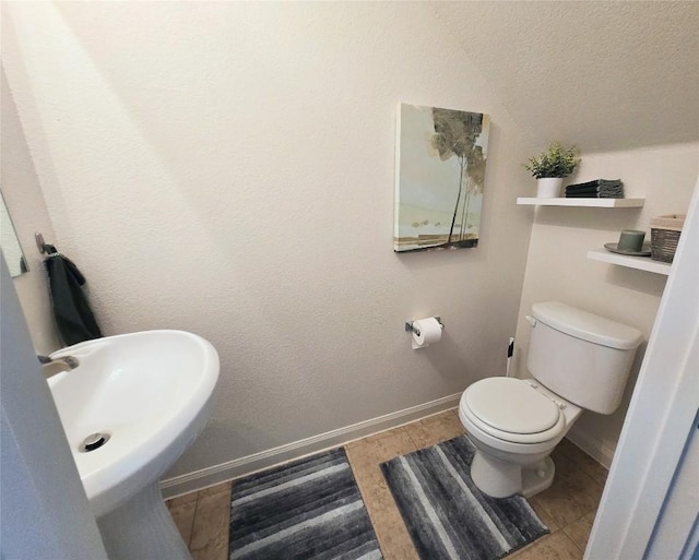 336 Farmer Ln, Jarrell, TX 76537 - bathroom with baseboards, toilet, a textured ceiling, a sink, and tile patterned flooring