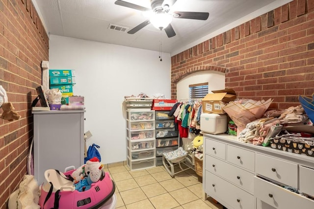 176 Old Lexington Rd Unit C, Elgin, TX 78621 - bedroom with brick wall, light tile patterned floors, and ceiling fan