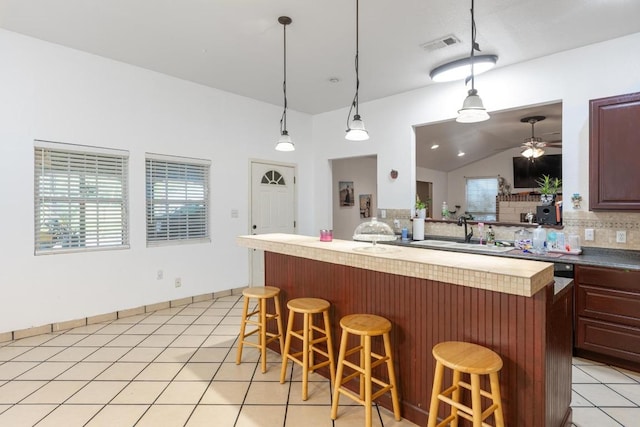 176 Old Lexington Rd Unit C, Elgin, TX 78621 - kitchen featuring backsplash, a ceiling fan, lofted ceiling, a kitchen breakfast bar, and hanging light fixtures