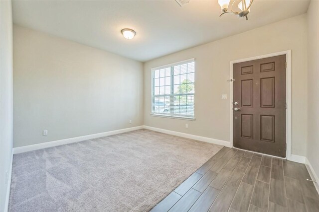 206 Duroc Dr, Hutto, TX 78634 - foyer featuring baseboards, wood finish floors, and a chandelier