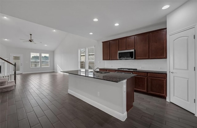 206 Duroc Dr, Hutto, TX 78634 - kitchen with stainless steel microwave, lofted ceiling, dark wood-style flooring, a sink, and decorative backsplash