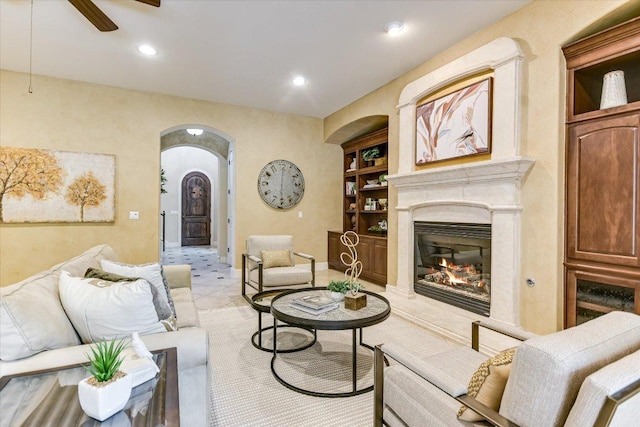 1036 Liberty Park Dr Unit 20, Austin, TX 78746 - living area featuring arched walkways, a ceiling fan, a fireplace, recessed lighting, and built in shelves