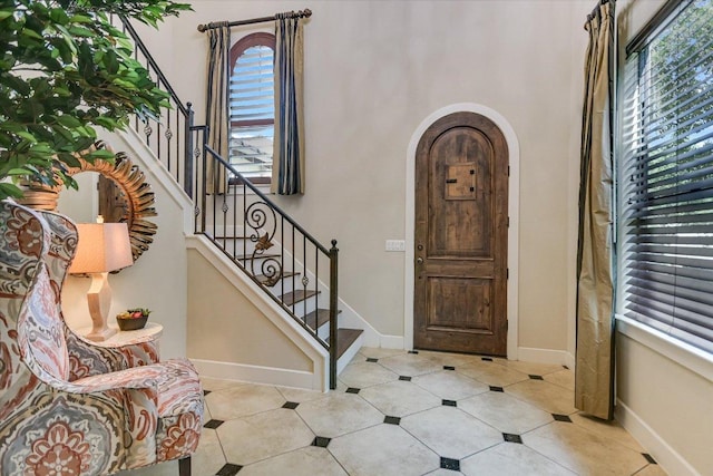 1036 Liberty Park Dr Unit 20, Austin, TX 78746 - entryway featuring arched walkways, baseboards, stairway, and tile patterned flooring