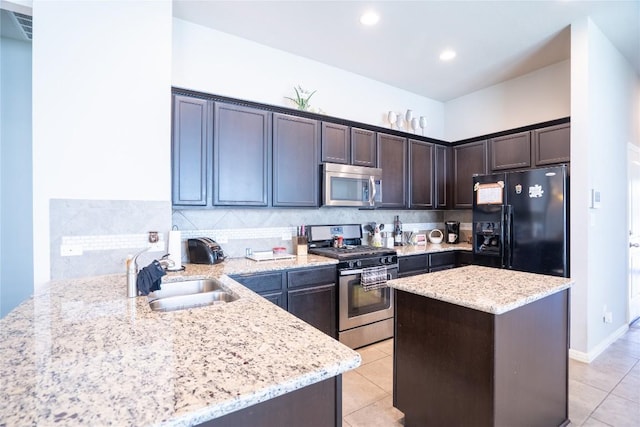 411 Tilly Ln, Buda, TX 78610 - kitchen with appliances with stainless steel finishes, light stone counters, dark brown cabinetry, light tile patterned floors, and recessed lighting
