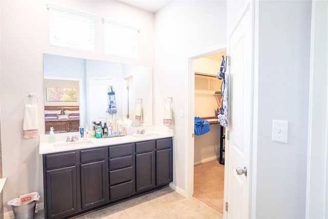 411 Tilly Ln, Buda, TX 78610 - full bath featuring double vanity, a walk in closet, tile patterned floors, and a high ceiling
