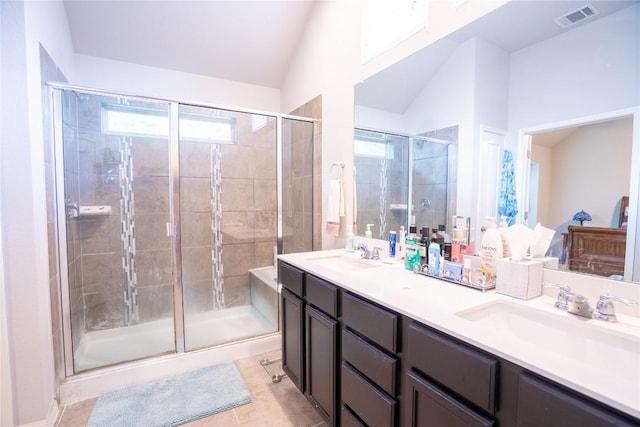 411 Tilly Ln, Buda, TX 78610 - bathroom featuring lofted ceiling, a stall shower, double vanity, healthy amount of natural light, and tile patterned floors