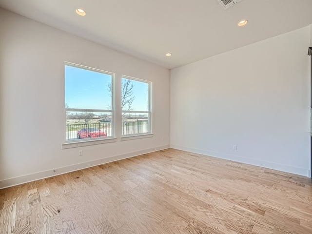 unfurnished room with light wood finished floors, recessed lighting, and baseboards