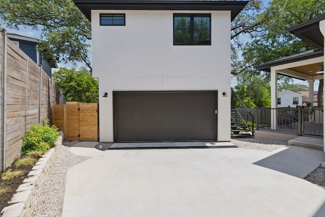 garage featuring driveway and fence
