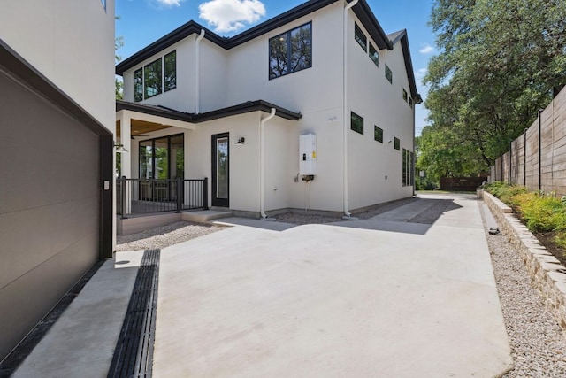 back of house featuring stucco siding, fence, and a patio