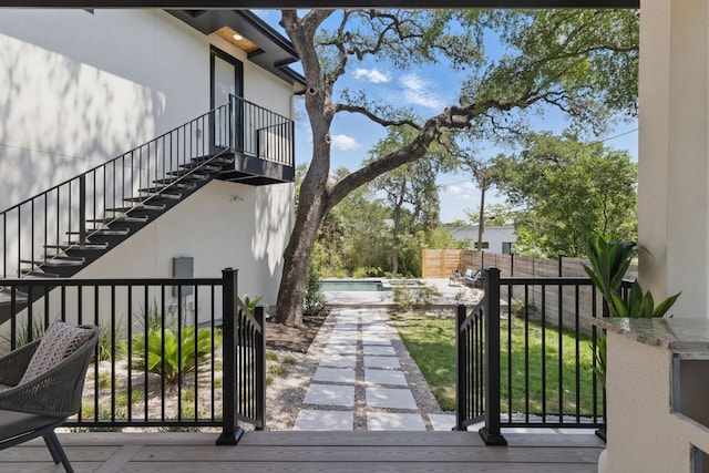 view of side of home featuring stairs, stucco siding, and fence