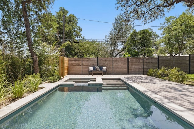view of pool featuring a fenced backyard and a pool with connected hot tub