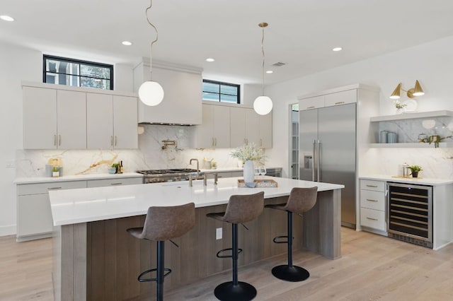 kitchen featuring beverage cooler, built in fridge, tasteful backsplash, light wood-type flooring, and recessed lighting