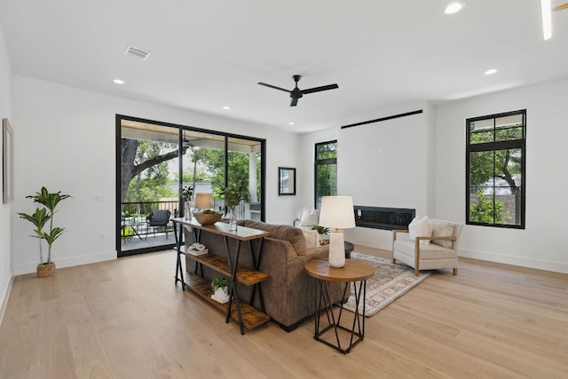 living area with a ceiling fan, light wood-style floors, recessed lighting, and baseboards