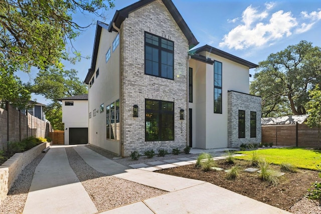 2304 W 8th, Austin, TX 78703 - modern home featuring brick siding, a garage, driveway, and stucco siding