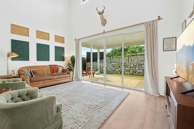 living room featuring plenty of natural light, wood finished floors, and a high ceiling