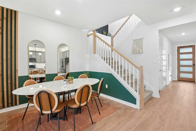dining space with stairway, light wood-style flooring, recessed lighting, and baseboards